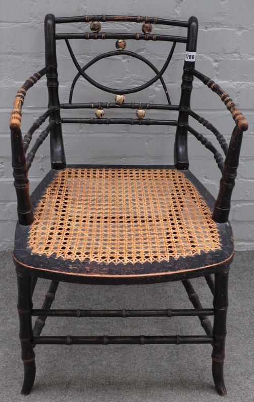 A Regency ebonised and parcel gilt faux bamboo open armchair, on splayed supports, 47cm wide x 78cm high.