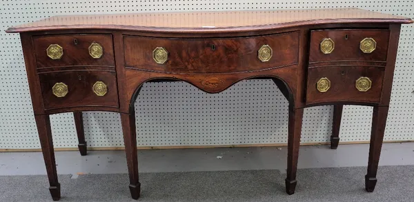 A George III mahogany sideboard, the serpentine front with three frieze drawers on tapering square supports, 183cm wide x 93cm high.