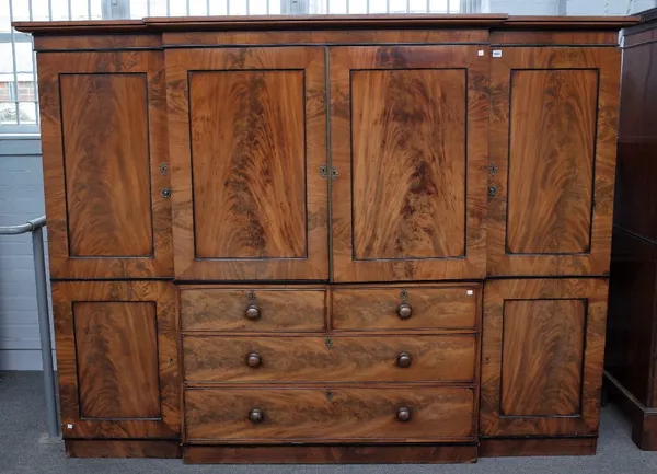 An early Victorian mahogany breakfront compactum wardrobe, on plinth base, 235cm wide x 178cm high.