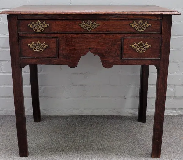 An 18th century oak lowboy, with three frieze drawers, on canted block supports, 76cm wide x 69cm high.