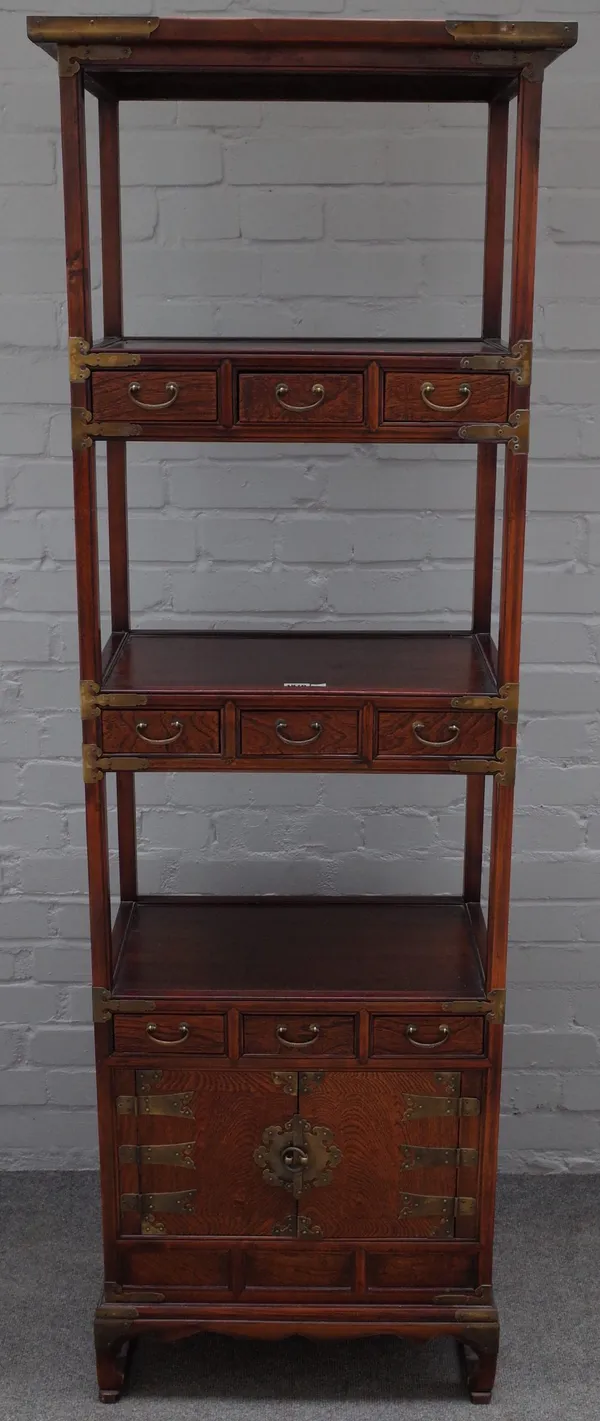 A 20th century Chinese elm side cabinet / what-not, with three open tiers, divided by drawers over a pair of cupboards, 58cm wide x 175cm high.