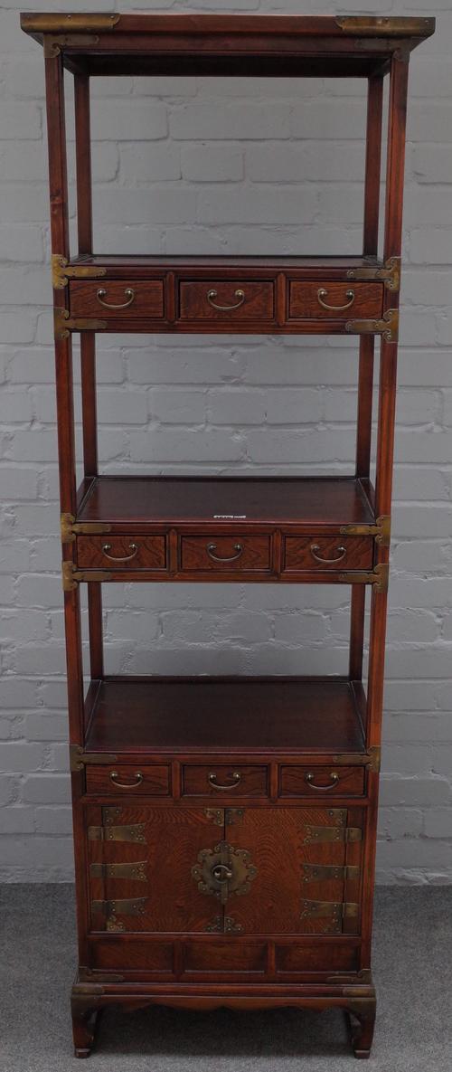 A 20th century Chinese elm side cabinet / what-not, with three open tiers, divided by drawers over a pair of cupboards, 58cm wide x 175cm high.