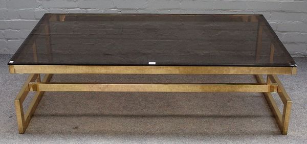 A rectangular smoked glass and lacquered brass coffee table, on geometric box frame, 140cm wide x 42cm high.