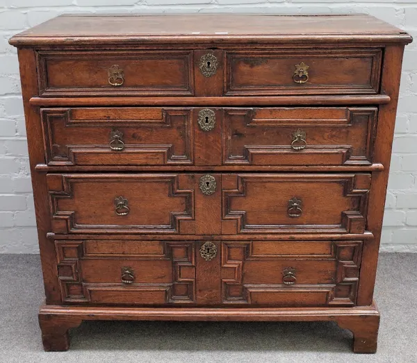 A Charles II oak chest, of four long geometric drawers, 104cm wide x 97cm high.