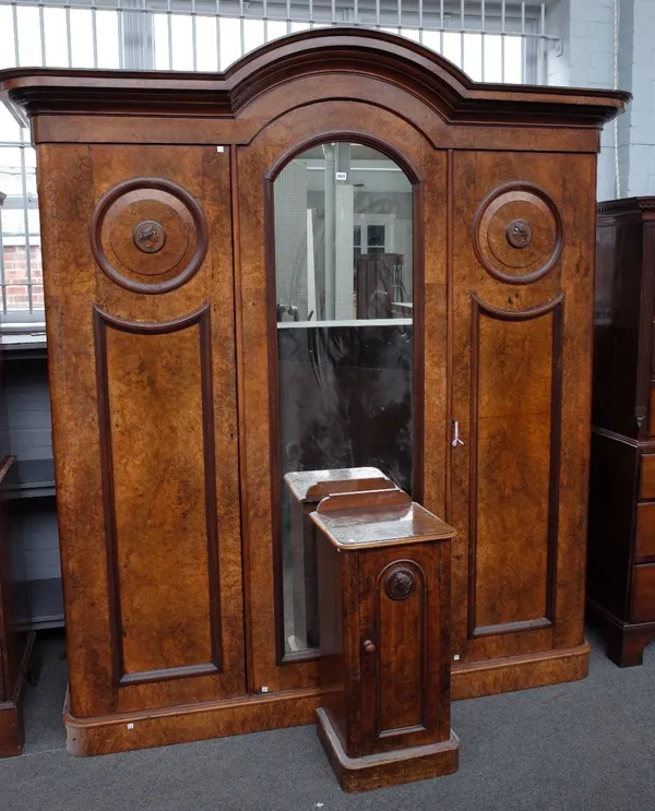 A Victorian figured walnut arch top triple wardrobe, with mirrored door flanked by relief side profile of female busts, on plinth base, 213cm wide x 2