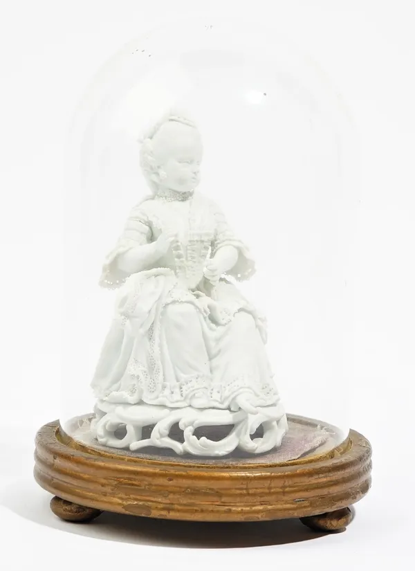 A Meissen white biscuit figure of a young woman, late 18th century, modelled seated holding a shuttle in her right hand, incised crossed swords inside