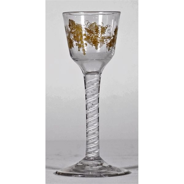 An opaque twist wine glass, circa 1765, the ogee bowl gilded, possibly later, with fruiting vine, raised on a double-series opaque twist stem and plai