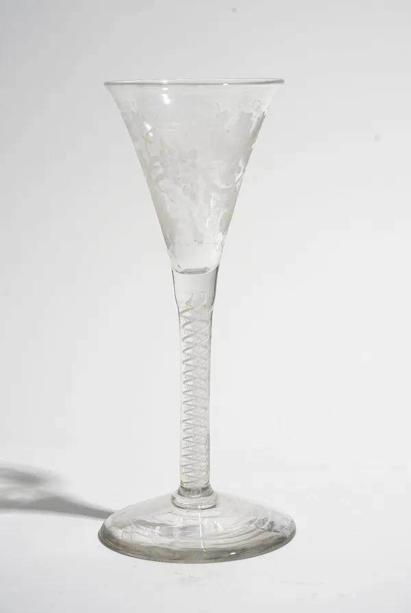 An opaque twist wine glass, circa 1765, the drawn trumpet bowl engraved with fruiting vine and an insect, raised on a double series opaque twist stem