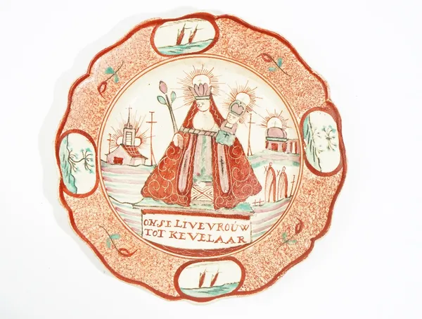 A small Dutch decorated Leeds creamware plate, circa 1775-85, painted with the Virgin Mary and Jesus flanked by chapels above the inscription, `Onse L