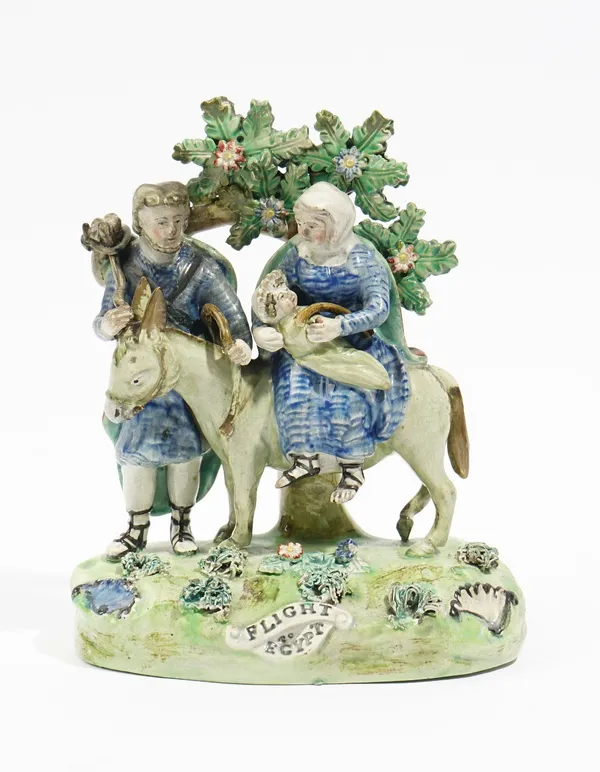 A Walton pearlware group of `Flight To Egypt', circa 1820-30, of traditional form, raised on a title grassy base, the reverse with upper case scroll m