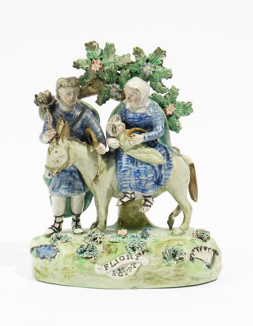 A Walton pearlware group of `Flight To Egypt', circa 1820-30, of traditional form, raised on a title grassy base, the reverse with upper case scroll m