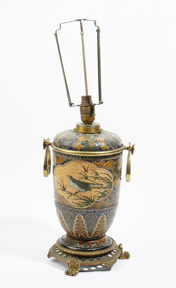 A Doulton Lambeth stoneware oil lamp (converted to electricity), dated 1881, decorated by Florence Barlow with two quatrelobed panels of a bird in bra