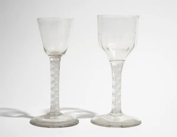 Two opaque twist wine glasses, circa 1765, the taller with moulded ogee bowl, the smaller with rounded funnel bowl, each raised on a double series opa