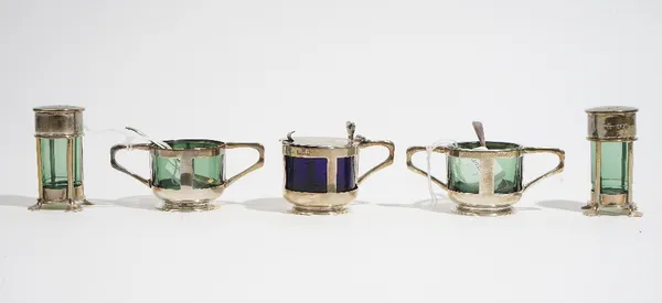 A silver five piece composite condiments set, comprising: a mustard pot, London 1904, (with a replacement blue glass liner), a pair of twin handled sa