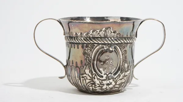 An early George III silver twin handled cup, with embossed fluted decoration below a reeded band, inscribed J D S 1765, height 7.5cm, London 1764, wei