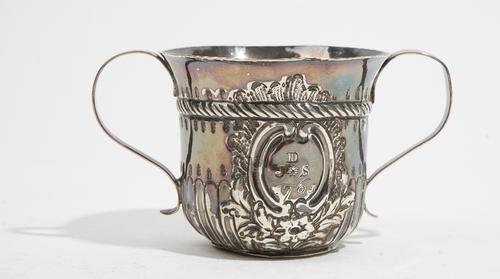 An early George III silver twin handled cup, with embossed fluted decoration below a reeded band, inscribed J D S 1765, height 7.5cm, London 1764, wei