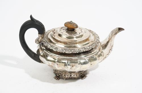 A George IV silver teapot, by Charles Price, London 1825, of fluted compressed circular form, with a hinged cover, a foliate rim, the oak leaf and aco