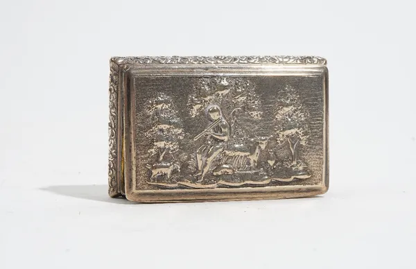 A George IV silver rectangular hinge lidded snuff box, the cover decorated with a figure playing a pipe, animals and trees beyond, the bombe sides wit