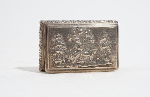 A George IV silver rectangular hinge lidded snuff box, the cover decorated with a figure playing a pipe, animals and trees beyond, the bombe sides wit