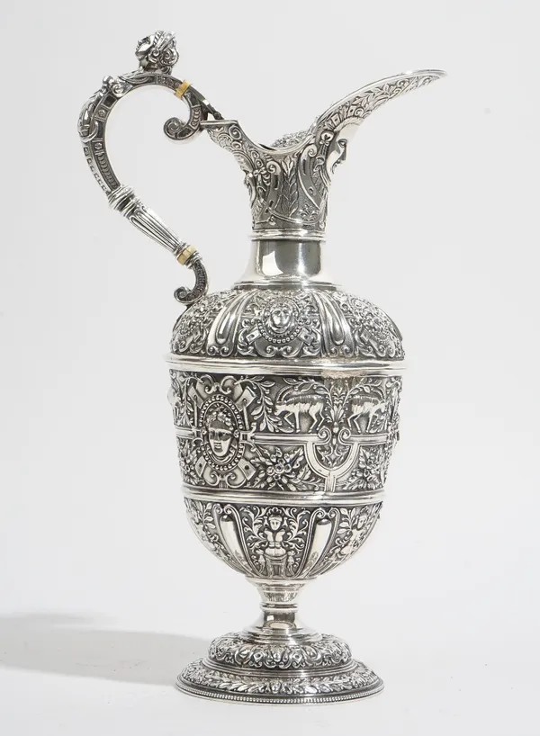 A Victorian silver Cellini pattern ewer, decorated with a mask to the hinge lidded spout and with a female classical mask to the handle, the body othe