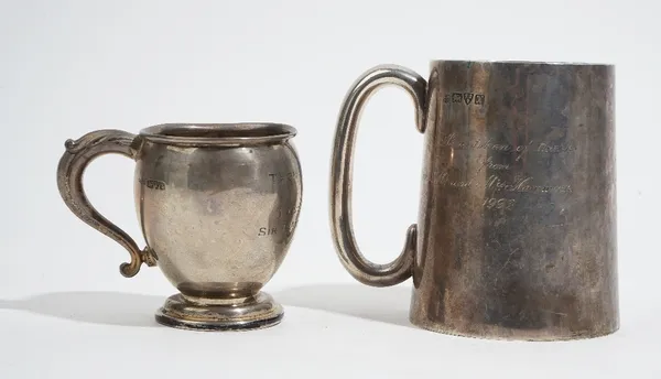 Silver, comprising; a large mug of tapered cylindrical form, with a 'C' shaped handle, presentation inscribed, height 11.3cm, Chester 1910 and another