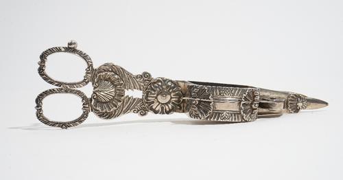 A pair of George III silver scissor action candle snuffers, with scalloped and scrolling decoration, engraved with a coat of arms and a motto, maker R