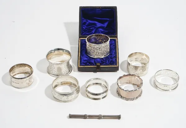 A Victorian silver napkin ring with embossed floral and foliate decoration, Birmingham 1890, with a case, seven further silver napkin rings, combined