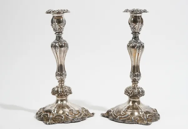 A pair of silver table candlesticks, decorated with foliate scrolls and floral sprays, with detachable sconces, raised on trefoil shaped bases, Sheffi