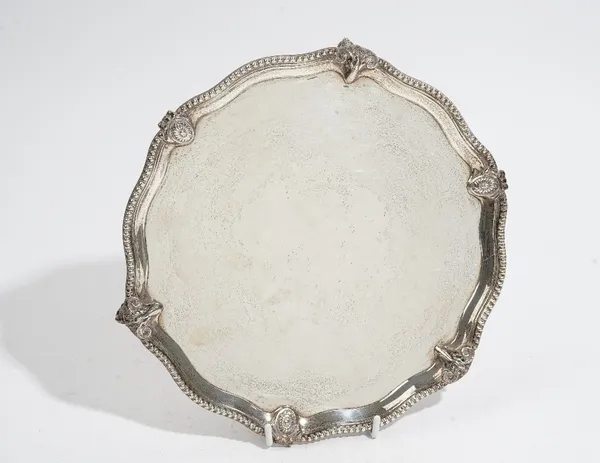 A silver salver, of shaped circular form, the bead edged border decorated with ram's masks alternating with oval floral panels having bow surmounts, r