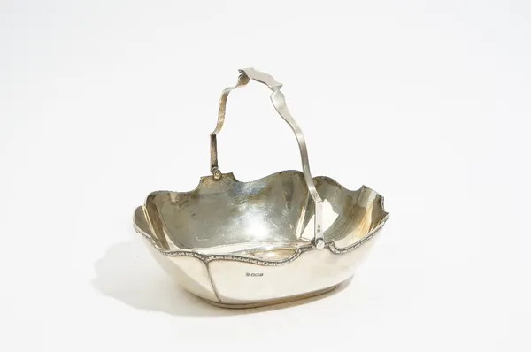 A silver cake or fruit basket, of shaped oval form, with a swingover handle, Sheffield 1923, length 24cm, weight 530 gms.