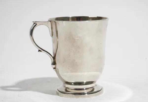 A silver christening mug of inverted bell shaped form, the handle having a flat thumbpiece, raised on a circular foot, height 10cm, London 1961, weigh