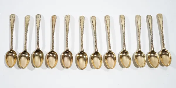 A set of twelve silver gilt, bottom marked, single struck, bead edged, Old English pattern teaspoons, crest engraved, combined weight 227 gms, (12),