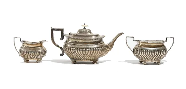 A silver three piece tea set, comprising; a teapot, a twin handled sugar bowl and a milk jug, each piece with partly spiral fluted decoration and rais