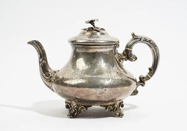 A Victorian silver teapot, of squat tapered circular form, with a scrolling handle, the hinged lid with a flower finial, the body with engraved decora