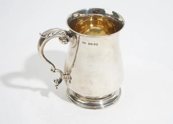 A Victorian silver baluster shaped mug, with a scrolling handle, raised on a circular foot, height 12.4cm, London 1860, maker probably Augustus George