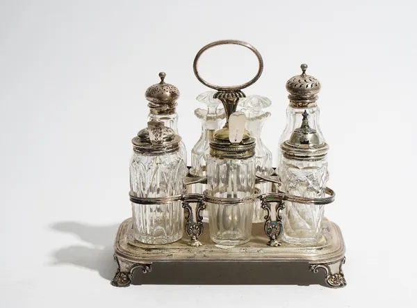 A silver eight bottle cruet frame, having an oval loop shaped handle, raised on four scrolled feet, probably London 1827, weight of frame 645 gms, wit