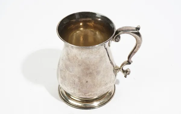 A late George II silver mug, of baluster form, with a scrolling handle, raised on a circular foot, London 1750, height 12cm, weight 367 gms.