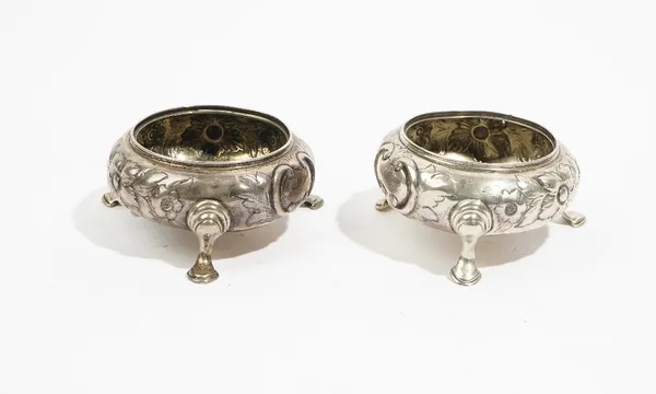 A pair of Victorian silver circular salts, each with floral and foliate embossed decoration, raised on three pad feet, London 1855, combined weight 14