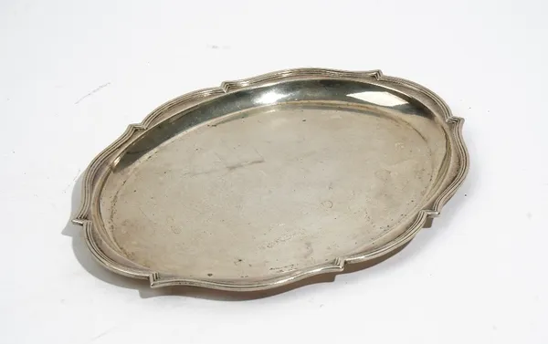 A silver dressing table tray of shaped oval form, having a reeded rim, London 1918, length 27cm, weight 342 gms..