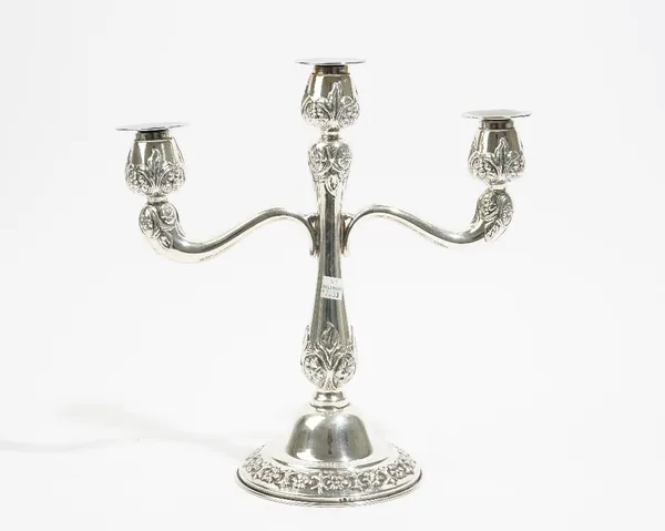 A foreign three branch table candelabra, with floral and foliate decoration, raised on a circular foot, with three detachable sconces, detailed Sterli