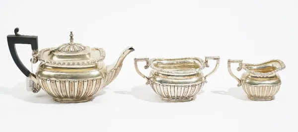 A late Victorian silver three piece tea set, by Elkington & Co. Ltd., Birmingham 1899, of baluster form, with partly fluted embossed decoration, gross