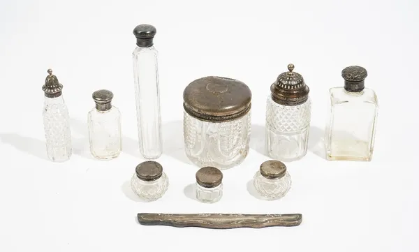 A silver twin handled trophy cup, nine various silver topped cut glass bottles and jars, a silver mounted dressing mirror and hairbrush and a comb mou