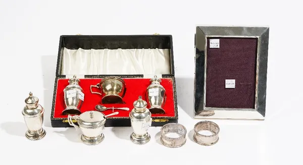 Silver, comprising; a three piece condiment set, comprising; a salt, a pepperette and a mustard pot with a blue glass liner, Birmingham 1974 and a mus