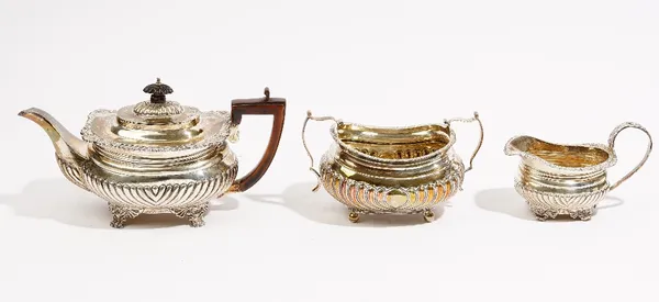 Silver tea wares, comprising; a teapot decorated with slanting fluted decoration, raised on four paw feet, with a composition handle and finial to the