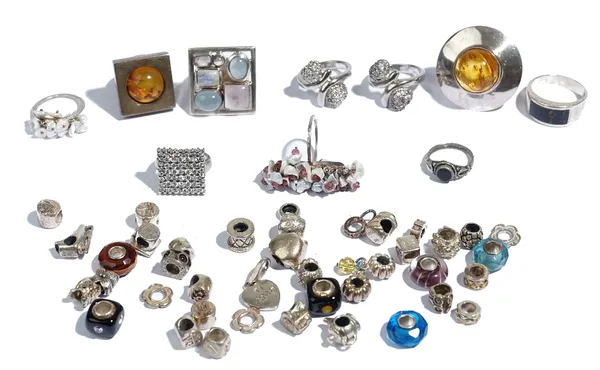 Ten mostly silver mounted rings, including two reconstituted amber rings and forty sliding beads for bracelets or necklaces, (50).