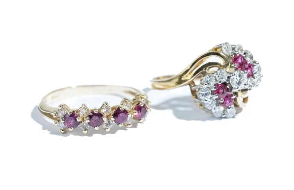 A gold, diamond and ruby ring, in a spiral cluster design, claw set with the principal circular cut diamond between diamond set serpentine sides and f