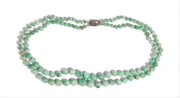 A two row necklace of jade beads, graduating in the size to the front, on a silver and marcasite clasp, detailed 925, gross weight 58 gms.