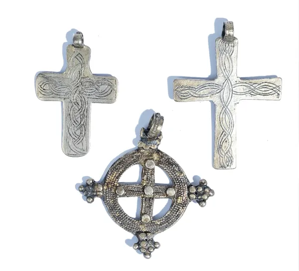 Three Coptic pendant crosses, the first of circular form, with a central cruciform motif and with beaded clusters decorating the border, the second an