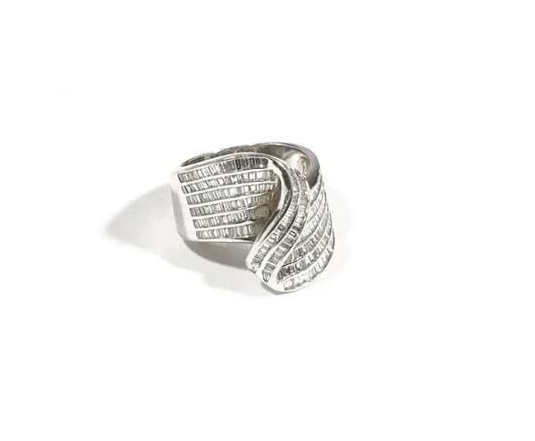 A white gold and diamond-set dress ring of cross-over wave scroll design, channel set throughout with baguette-cut diamonds, ring size L, 9.1gms, deta