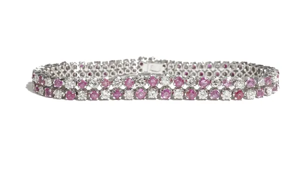 A pink sapphire and diamond bracelet, claw set with two rows of alternating circular cut pink sapphires and diamonds, on a snap clasp, detailed 750, l